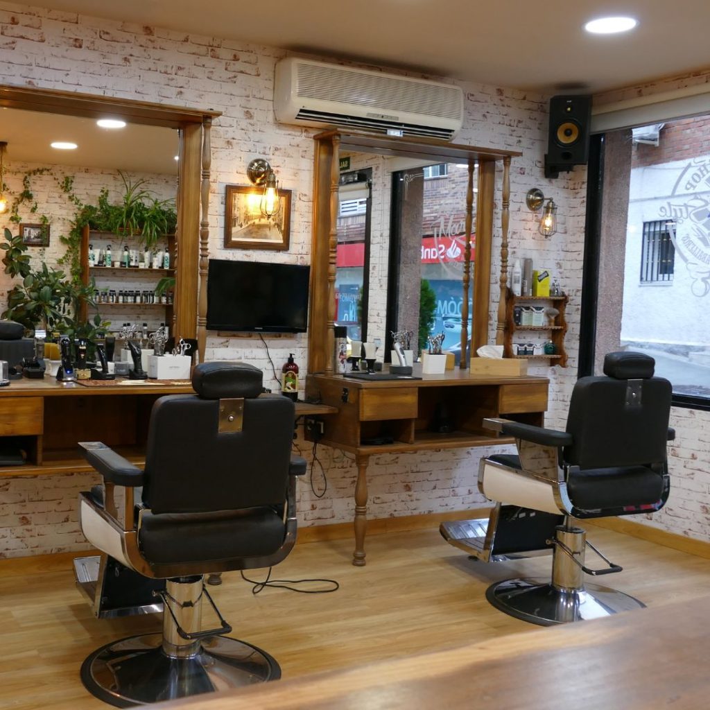 Zona de trabajo principal de la barbería Mario Style en Las Rozas con sillones de corte, espejos y productos de cuidado masculino.